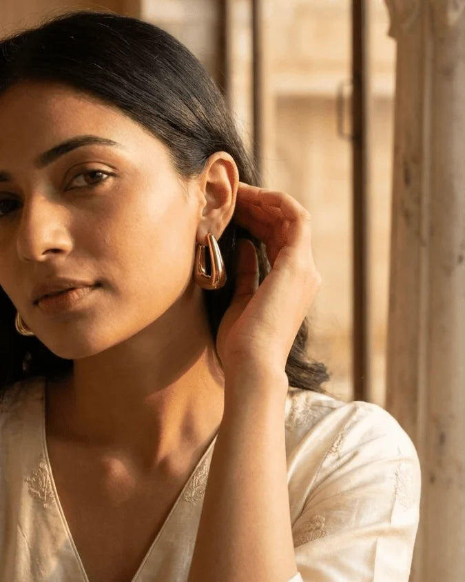 Model wearing Gold colour hoop earrings with half square hoop earrings and lightweight 