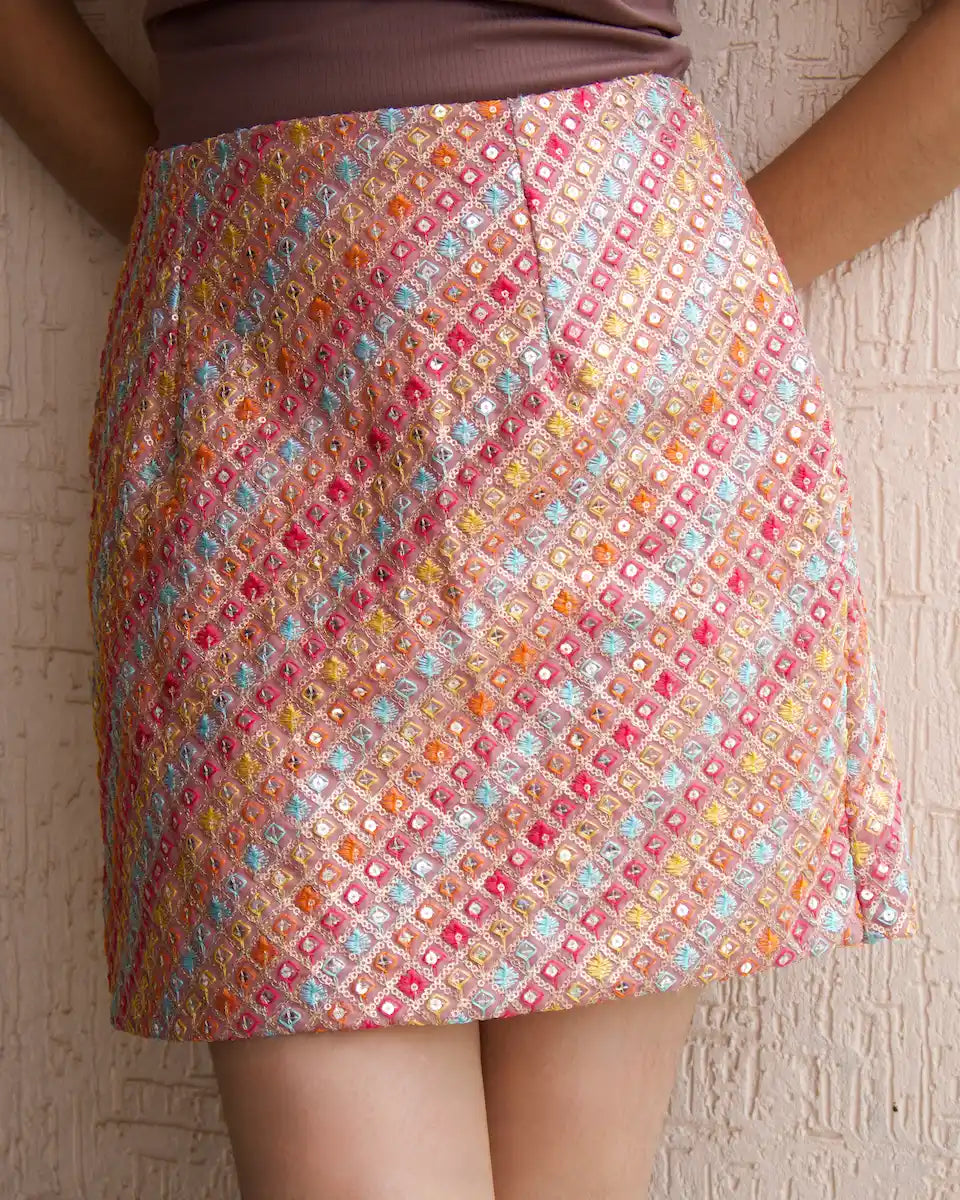 Dusty pink embroidered mini skirt with multicolour thread work and sequins, styled with a brown top