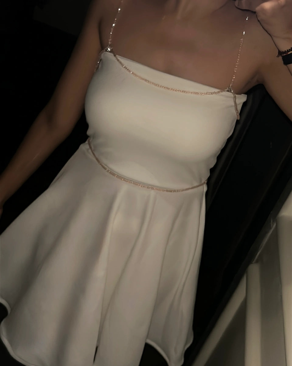 Model wearing Black mini tube dress with detachable beads accessories of shoulder and waist belt , white colour