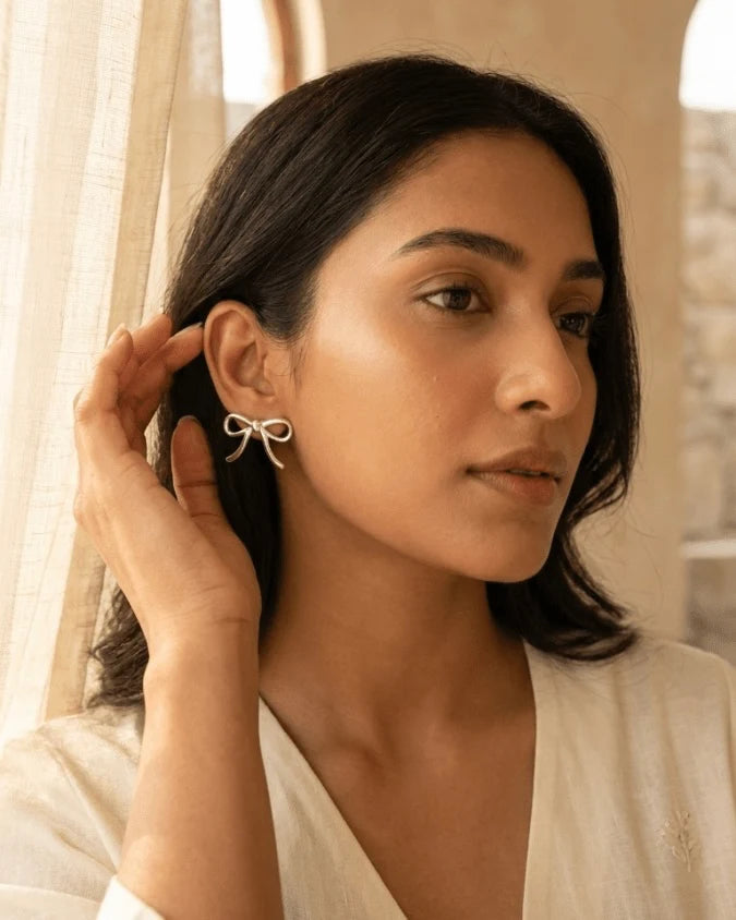 Model wearing Silver colour big bow shape earrings studs, light weight