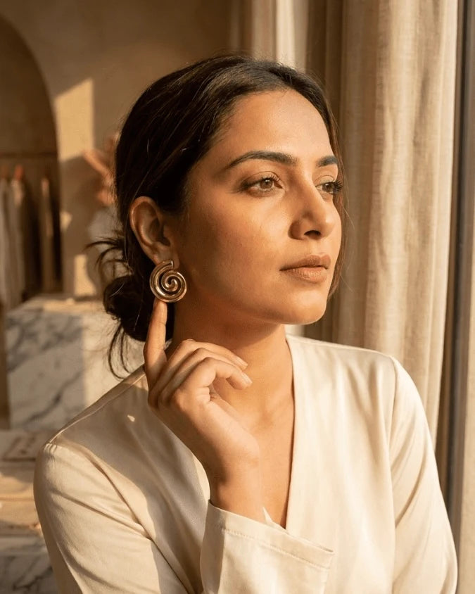 Model wearing Earrings with spiral shape and golden colour and very light weight earring