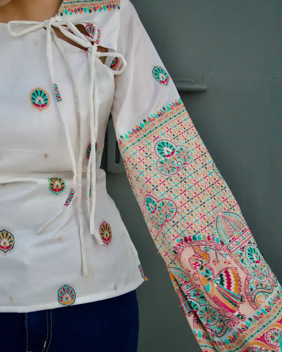 Close-up of the side tie neckline on a white ethnic top