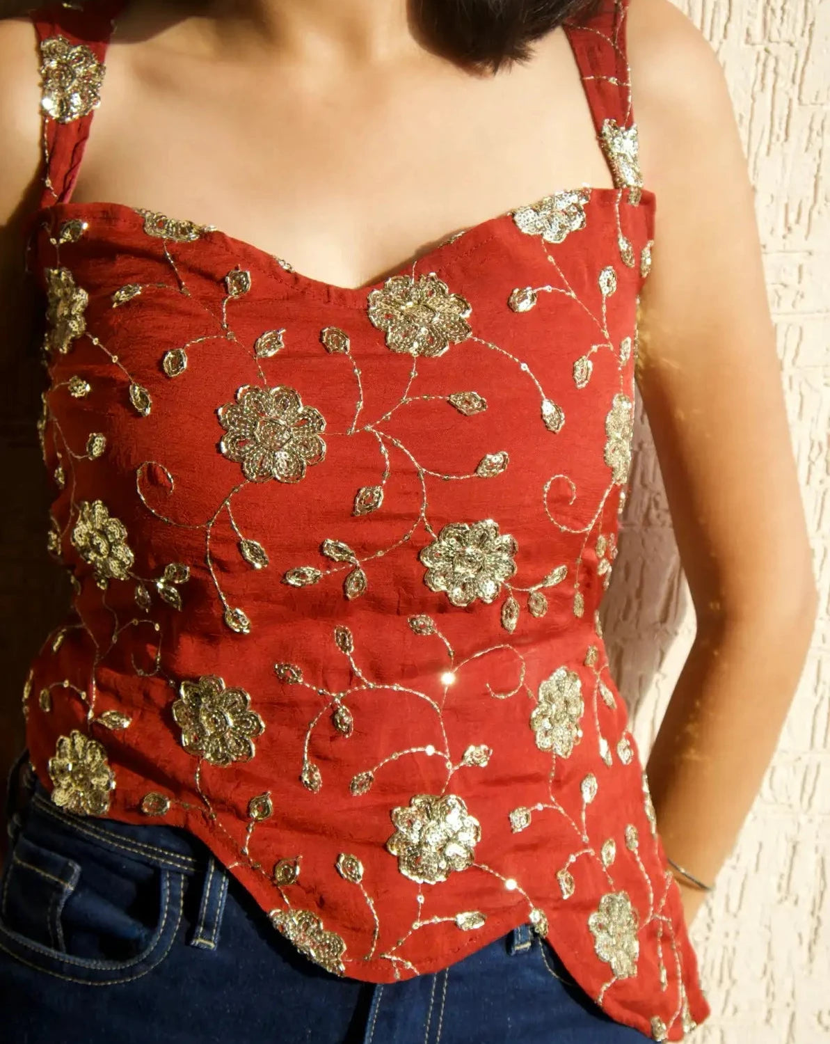 Model wearing y2k styled (chatpate) top with sweetheart neckline and rust colour.