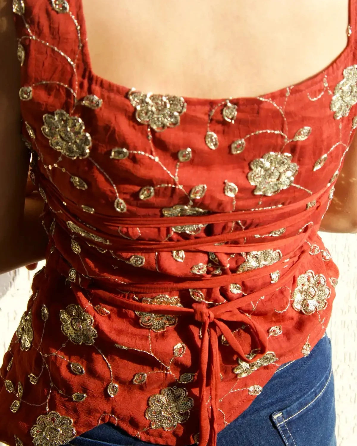 Model wearing y2k styled (chatpate ) top with sweetheart neckline and rust colour back tie 
