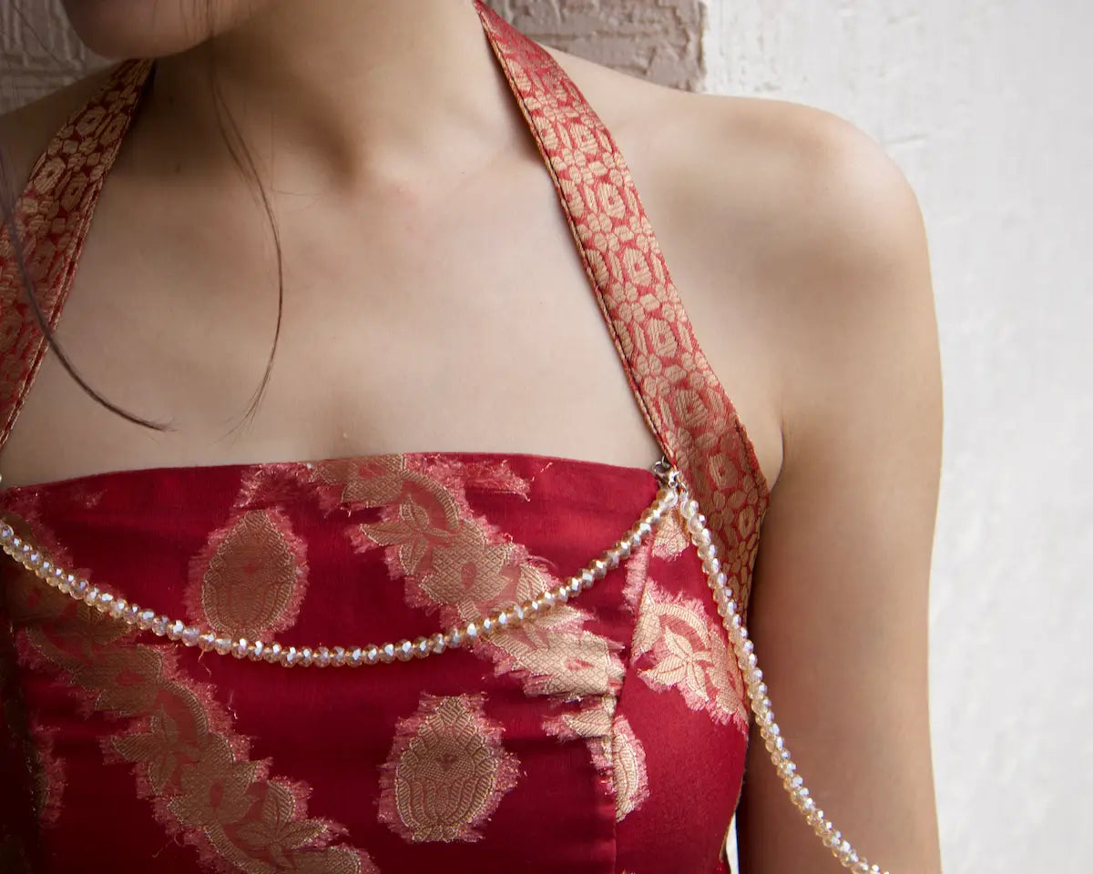 closeup of the maroon corset top neck that show halter neck straps and detachable beaded chain