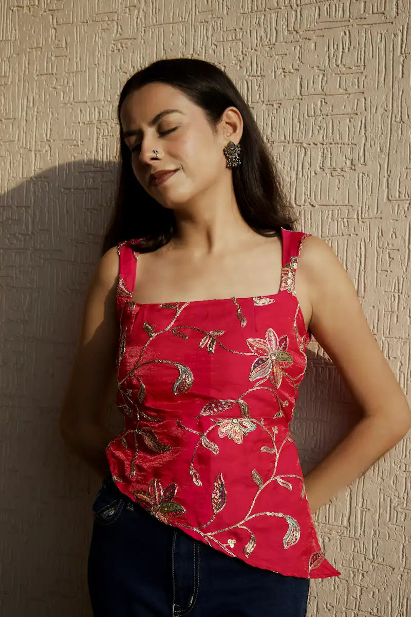 Dark pink embroidered square neck top with shimmery finish and asymmetric hem, styled with dark jeans